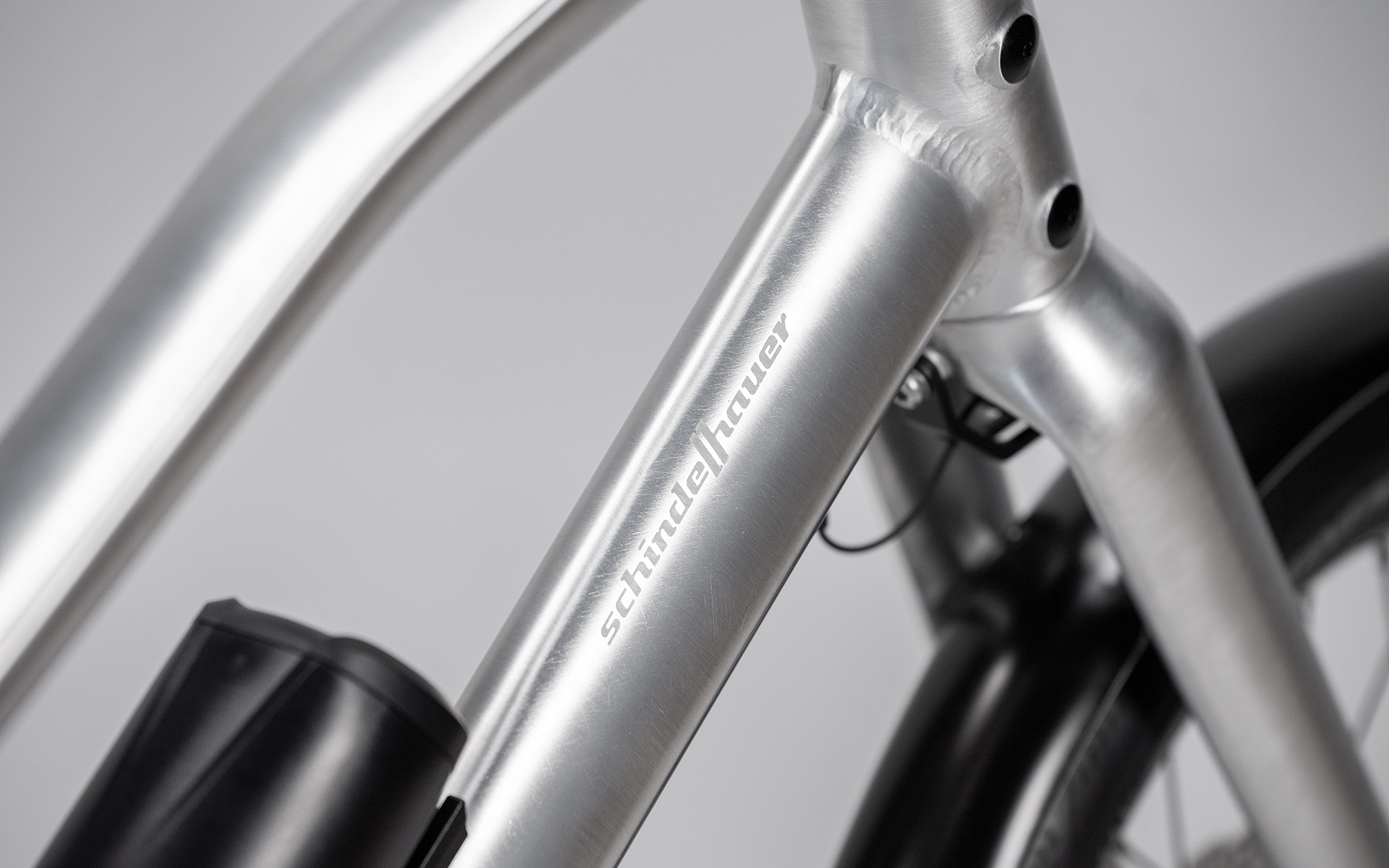 Het ruwe, met de hand geborstelde aluminium toont perfect de sculpturale schoonheid van het frame en de perfectie van de soepel gelaste naden volledig blootgelegd. Op de e-bike variant van Neo combineren we deze iconische afwerking met diepzwarte componenten. Het resultaat is een puristisch, karaktervol contrast dat technische evolutie naadloos samenbrengt met klassieke design-DNA.